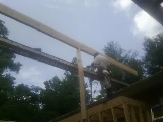 Carpenter setting a ridge beam over a new addition frame — Ice Dam Removal by Roofing Brothers in Aromas